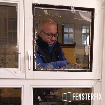 Ein Angestellter, der nach einem Einbruch ein neues Fenster einbaut.